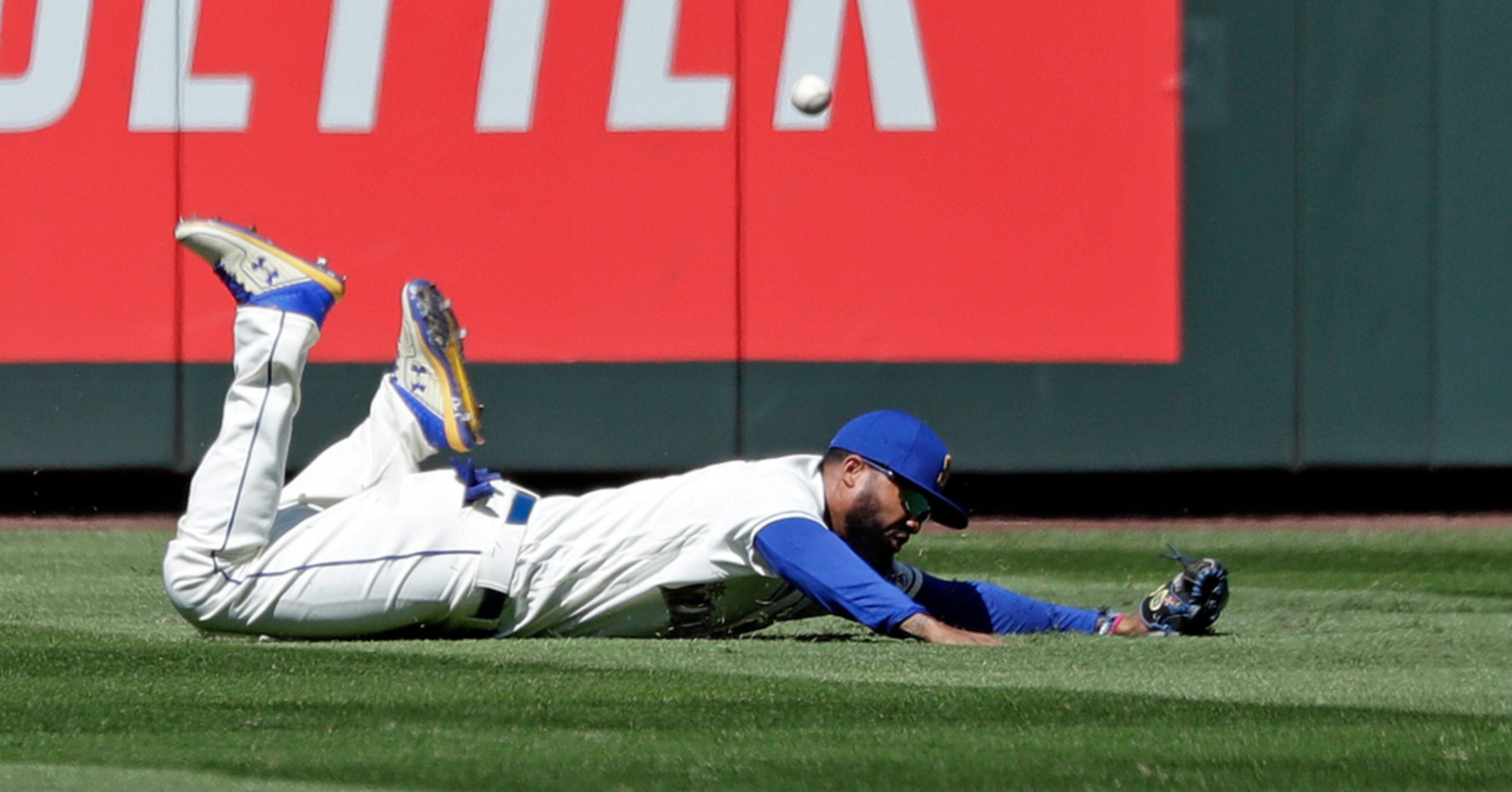 Seattle Mariners left fielder Domingo Santana misses on a dive for a hit from Texas Rangers'...