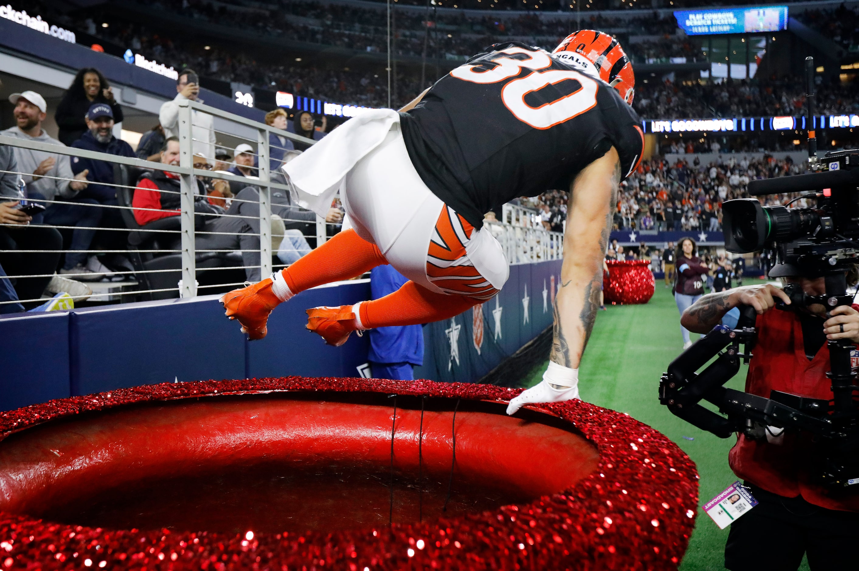 Cincinnati Bengals running back Chase Brown (30) leaps from the Salvation Army kettle...