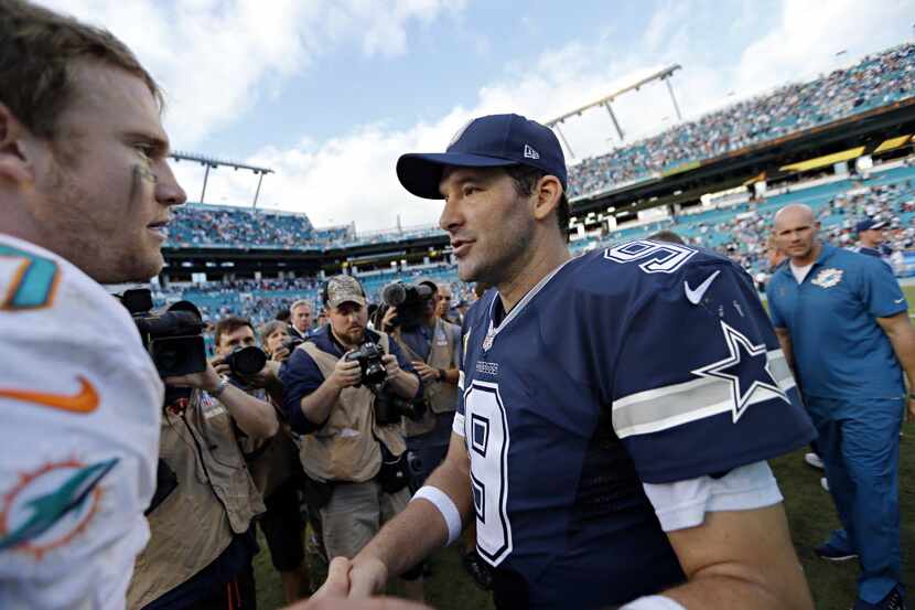 Dallas Cowboys quarterback Tony Romo (9) shakes hands with Miami Dolphins quarterback Ryan...