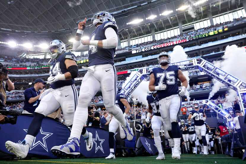Dallas Cowboys quarterback Dak Prescott (4) points skyward as he ands teammates enter AT&T...