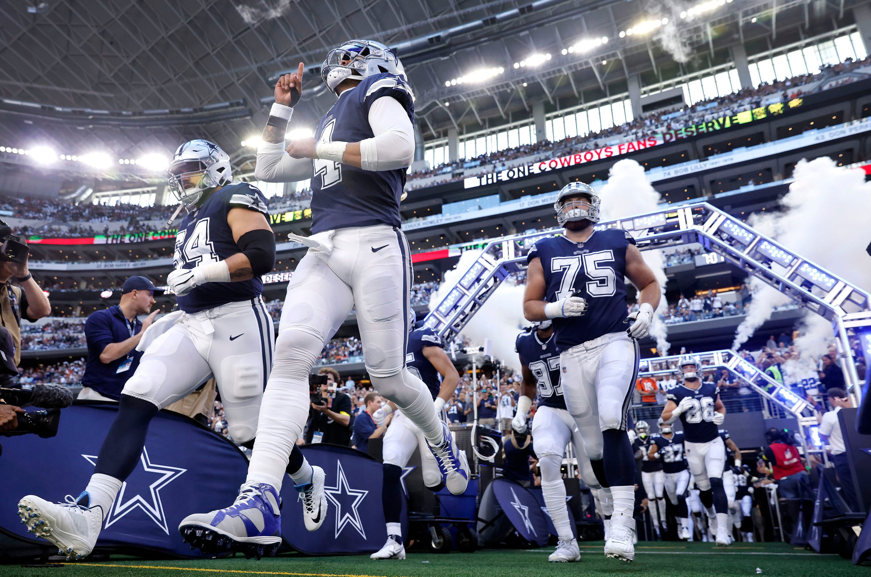 Dallas Cowboys quarterback Dak Prescott (4) points skyward as he ands teammates enter AT&T...