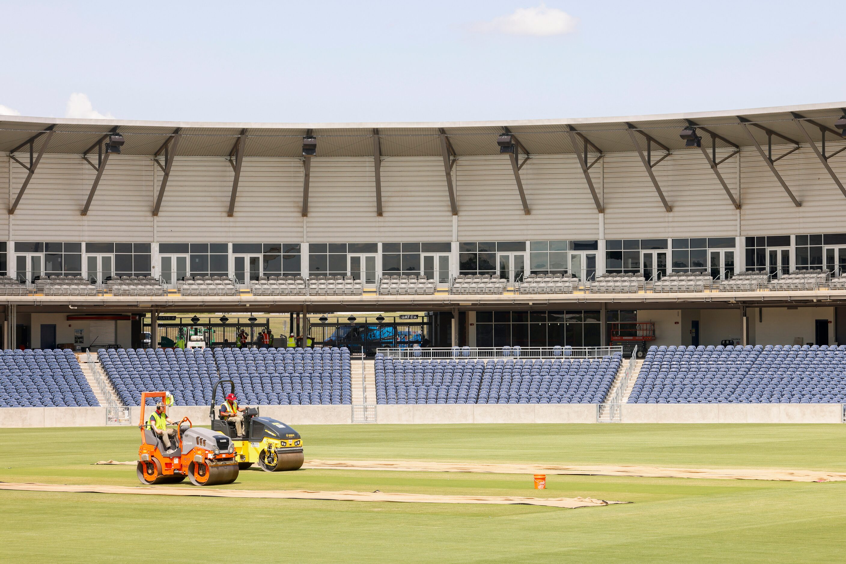 Groundsmen curate a cricket pitch on Thursday, July 6, 2023, at Grand Prairie Stadium, ahead...