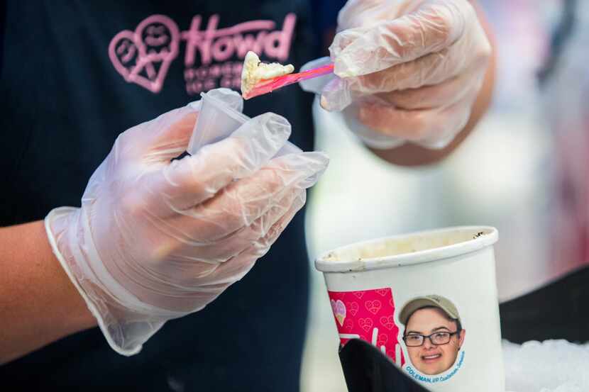 Coleman Jones, vice president of Howdy Homemade Ice Cream, hands out samples from a carton...