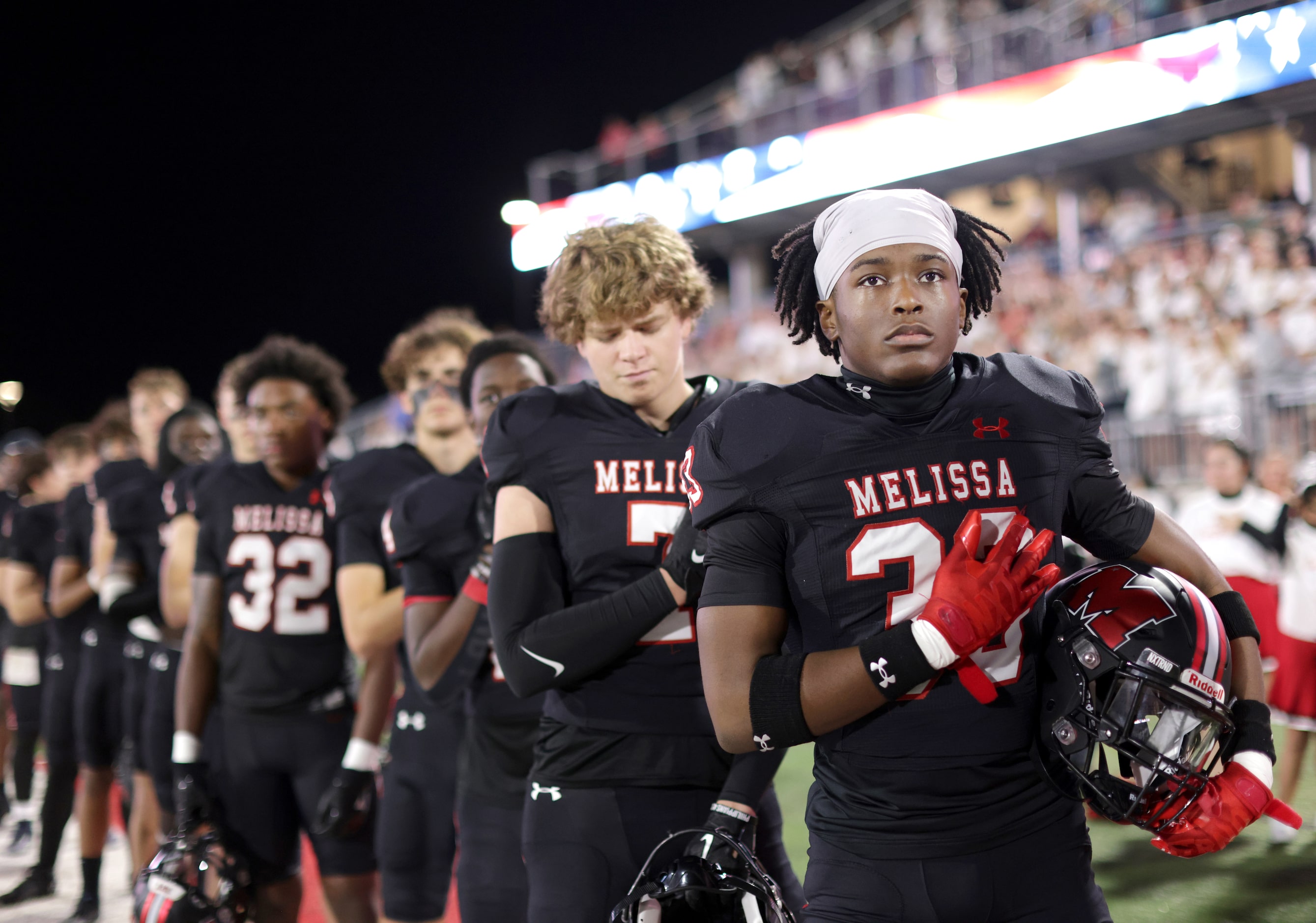 The Melissa team stands for the National Anthem before the start of the Prosper Walnut Grove...