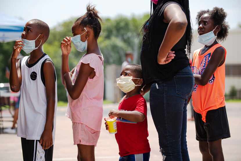 Miles Butler, 4 (center) waited in line for a snow cone during a Frazier Revitalization...