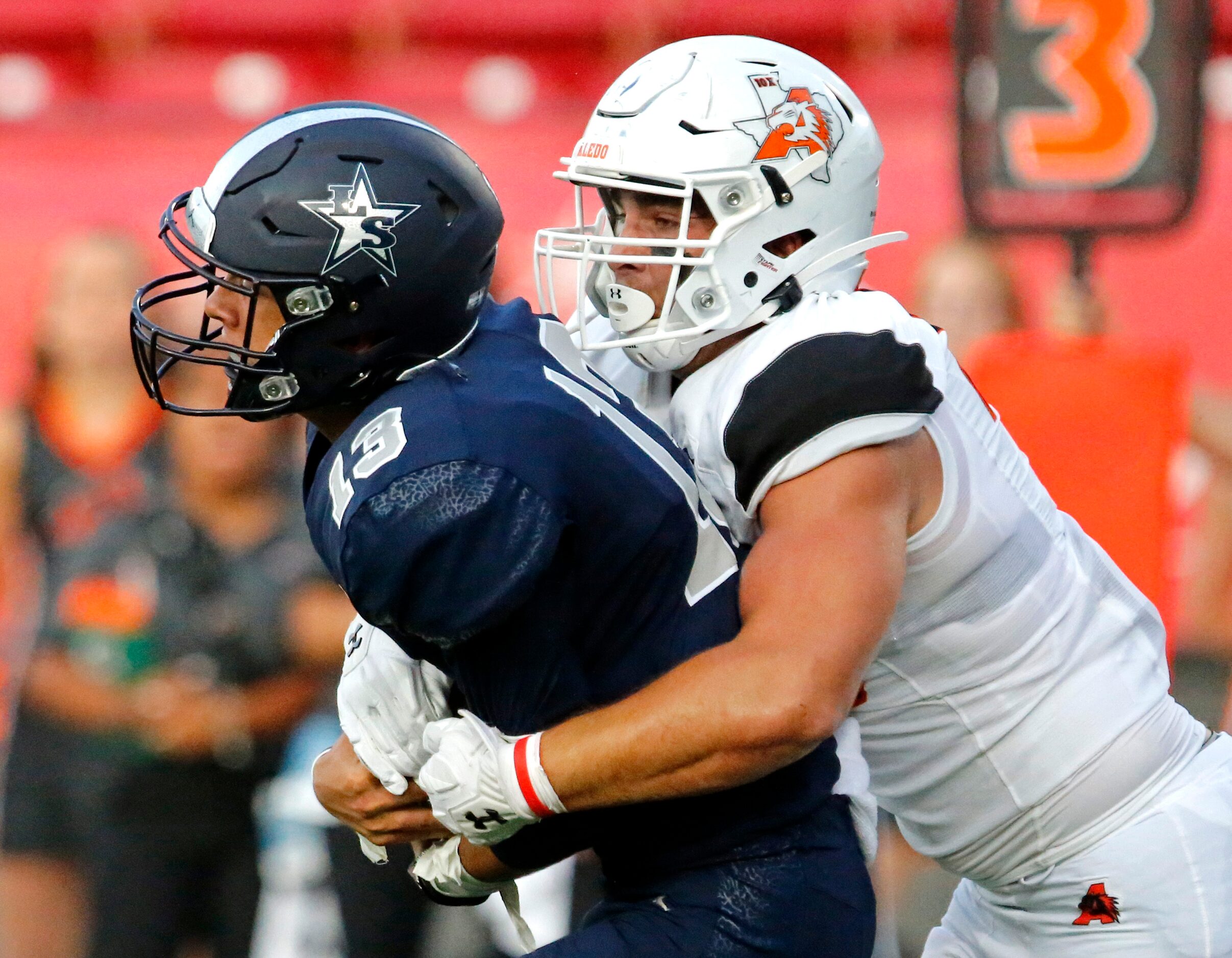 Lone Star High School quarterback Garret Rangel (13) is tackled by Aledo High School...