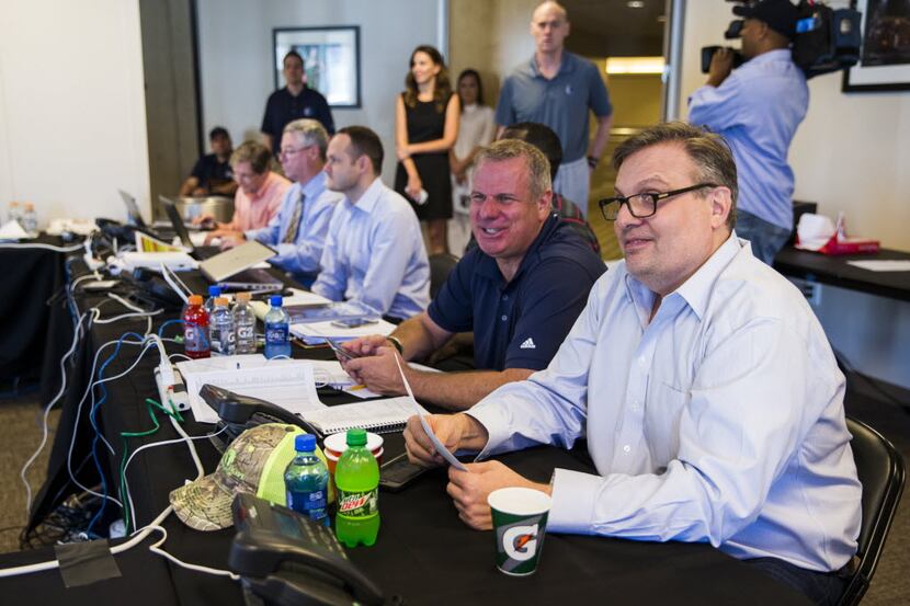 Dallas Mavericks general manager Donnie Nelson (right) talks draft picks in their draft room...