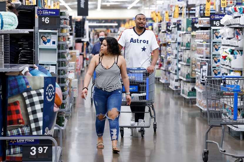 Dora Solis, 21 (left), and Steven Sims, 24, browse the aisles at a Walmart on Retail Road in...