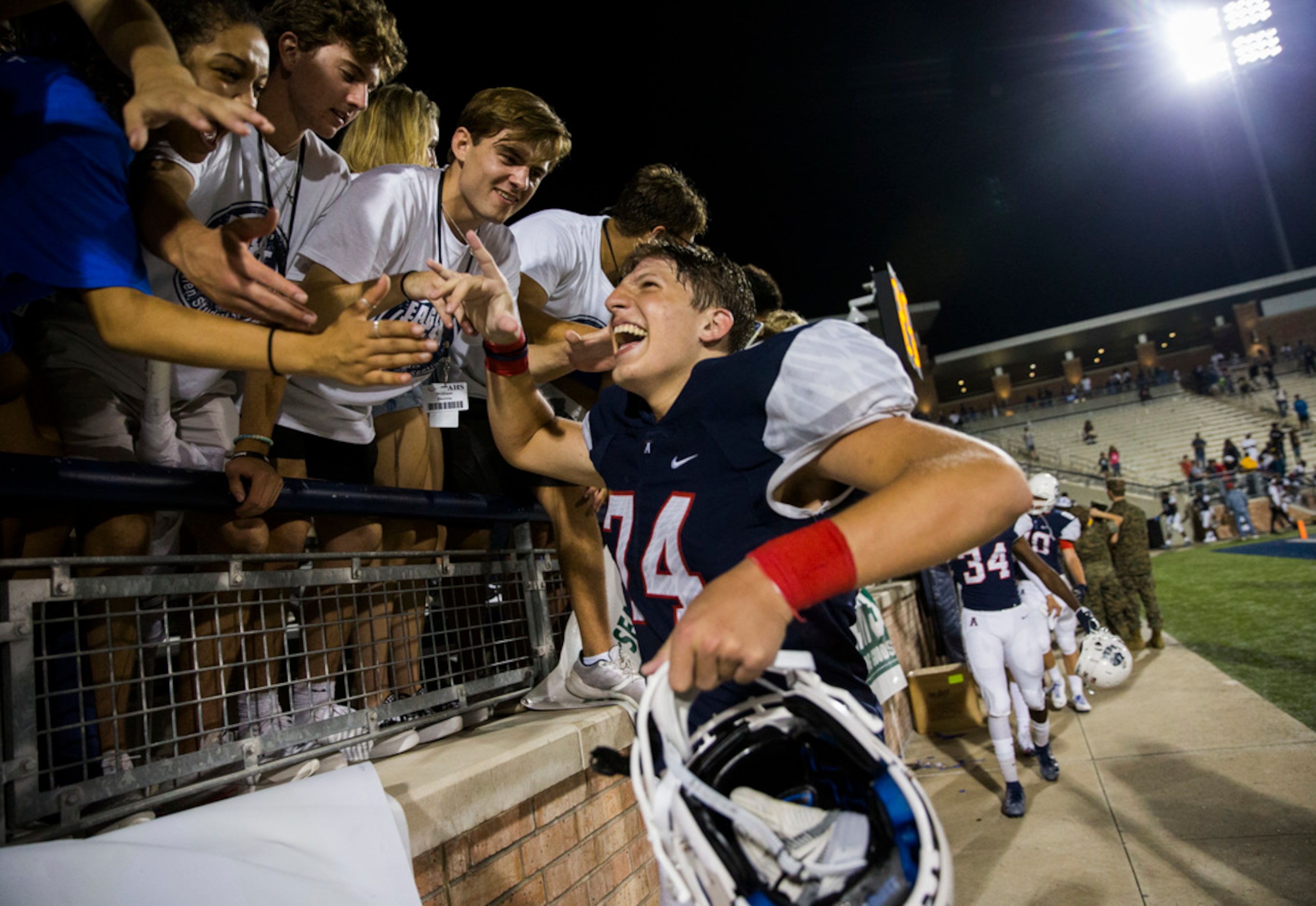 Allen offensive lineman Tanner Norris (74) high-fives fans after a 41-28 win over Cedar Hill...