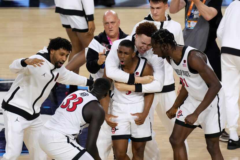 San Diego State guard Lamont Butler, center, celebrates with teammates after he hit the...