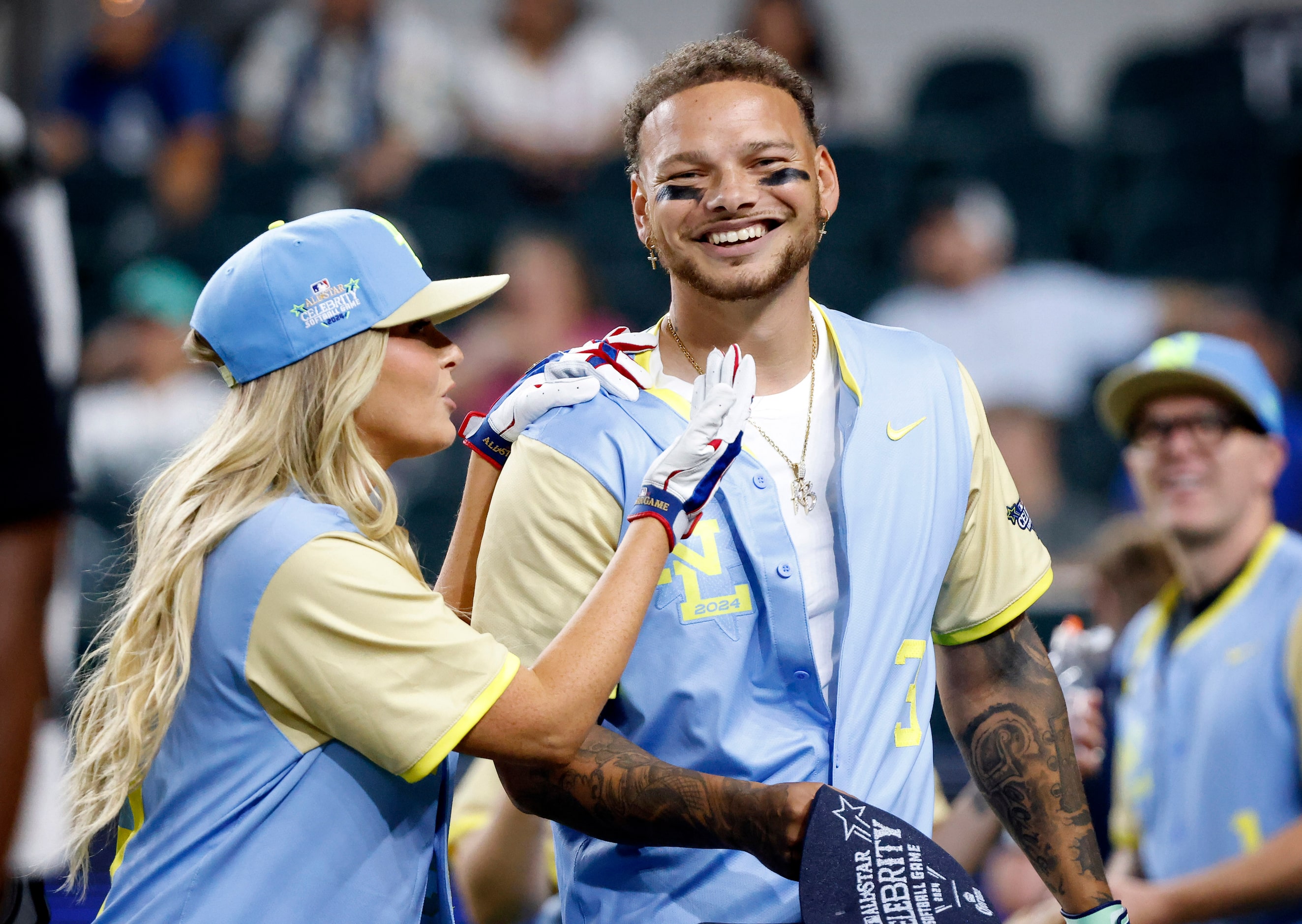 Country Music Singer Kane Brown is congratulated on his home run by model Camille Kostek...