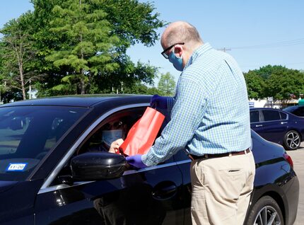 Interabang Books manager and partner Kyle Hall delivers books curbside to Joe Gall at the...