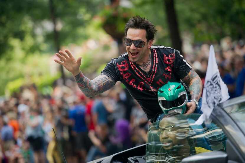 Jason David Frank waves to the crowd as he makes his way down Peachtree Street in the annual...