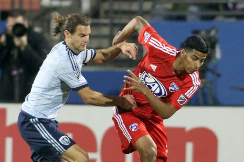 FC Dallas' Moises Hernandez (3) gets tied up with Sporting Kansas City's Graham Zusi (8) as...