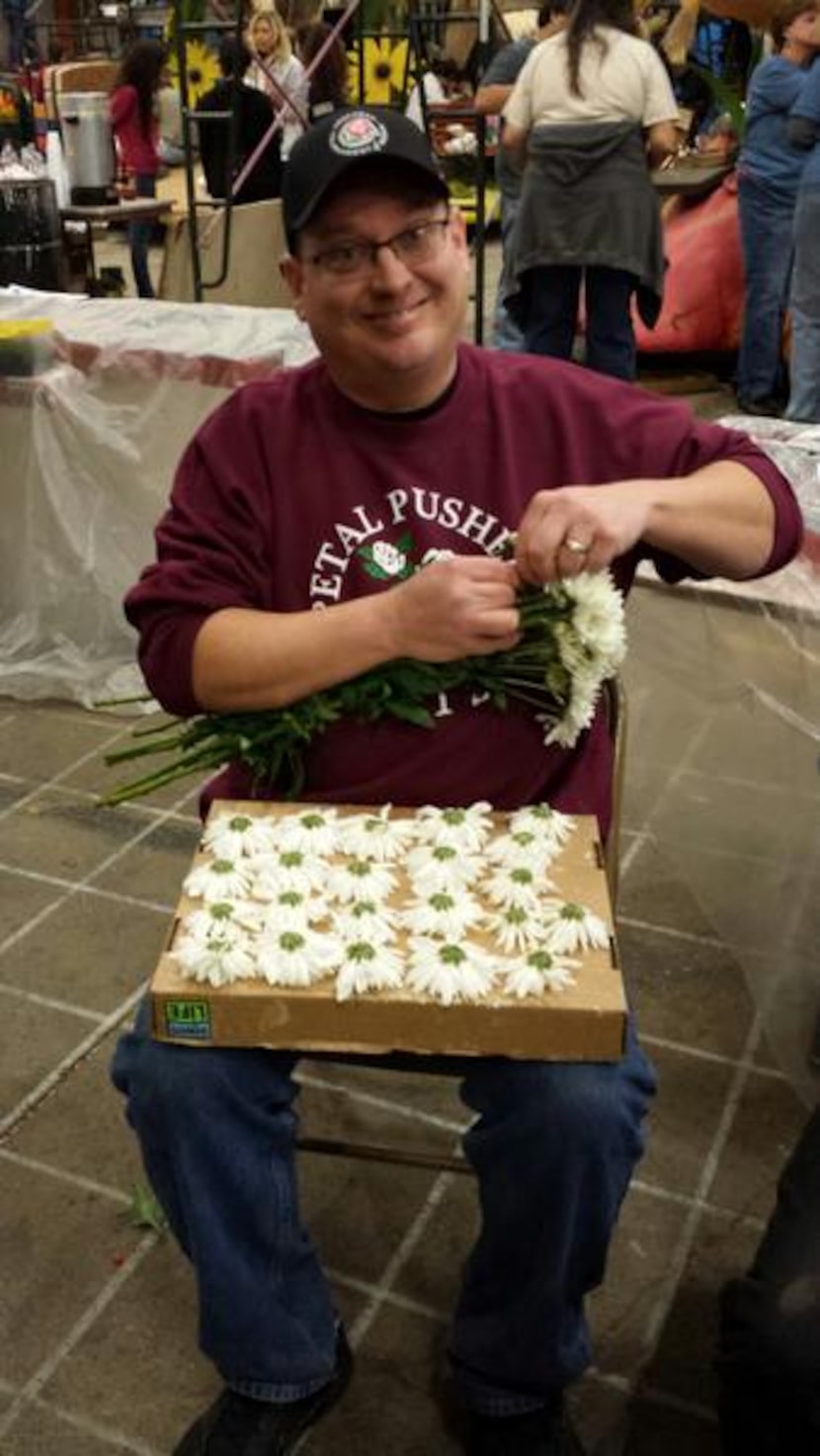 
Kyle McAfee removes flowers from their stems.
