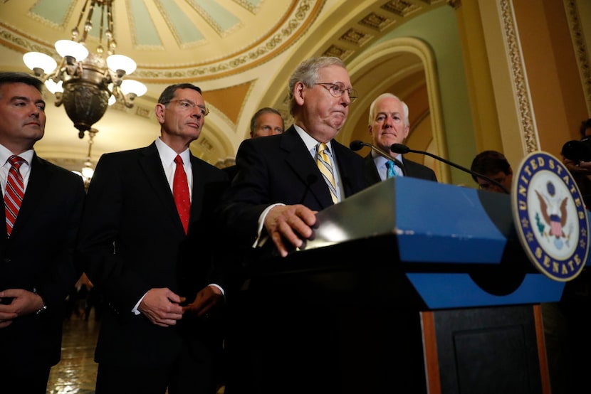 Senate Majority Leader Mitch McConnell (at lectern) of Kentucky, accompanied by (from left)...