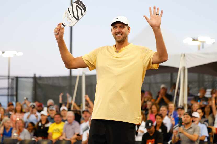 Dirk Nowitzki raises his arms as he is announced to the crowd as a pickleball player in the...