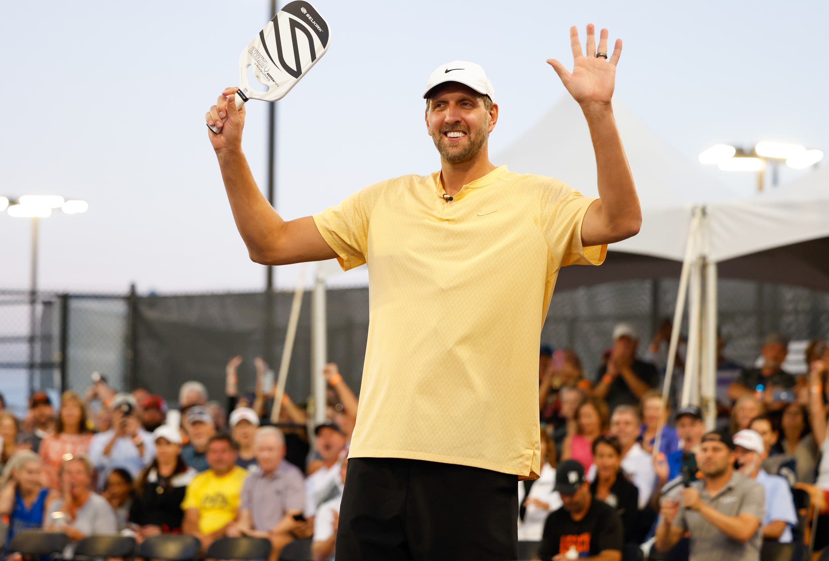 Dirk Nowitzki raises his arms as he is announced to the crowd as a pickleball player in the...