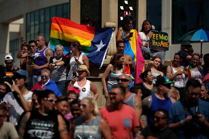 People view the 2017 Texas Freedom Parade from the Legacy of Love monument at Cedar Springs...