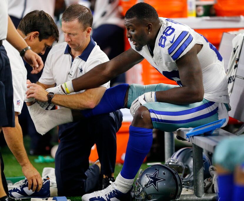 Dallas Cowboys wide receiver Dez Bryant (88) has his foot wrapped on the bench during the...