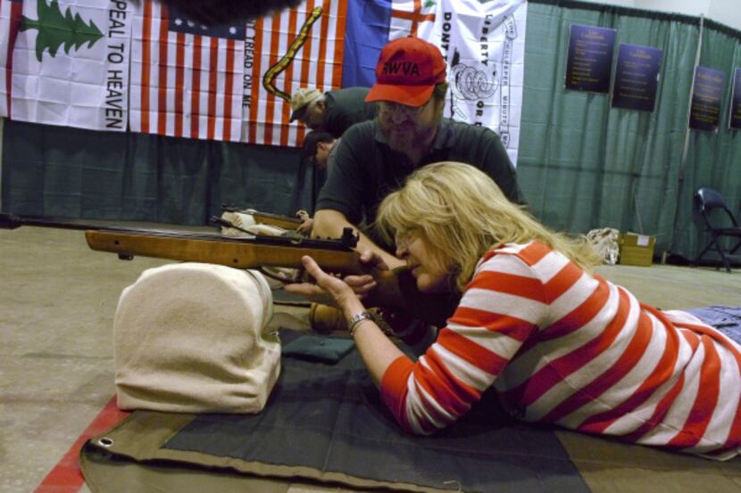 Debbie Woody of Duncanville took aim at a target under the watchful eye of Steve Rabe from...