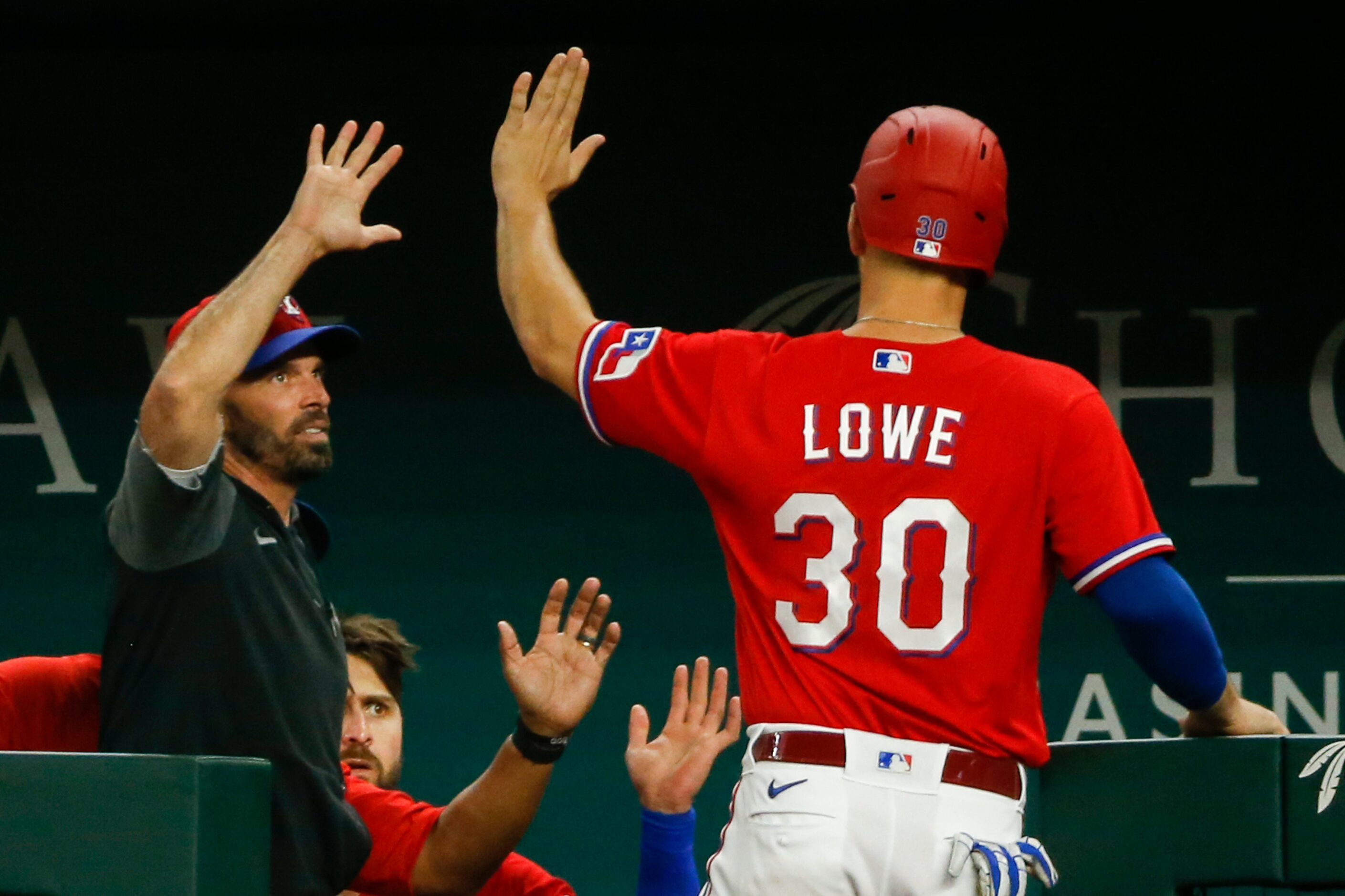 Texas Rangers first baseman Nate Lowe (30) high-fives Texas Rangers manager Chris Woodward...