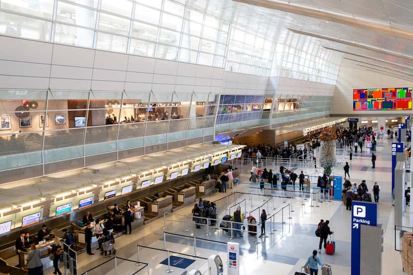 Travelers make their way through Terminal D at DFW International Airport on Friday, Dec. 21,...