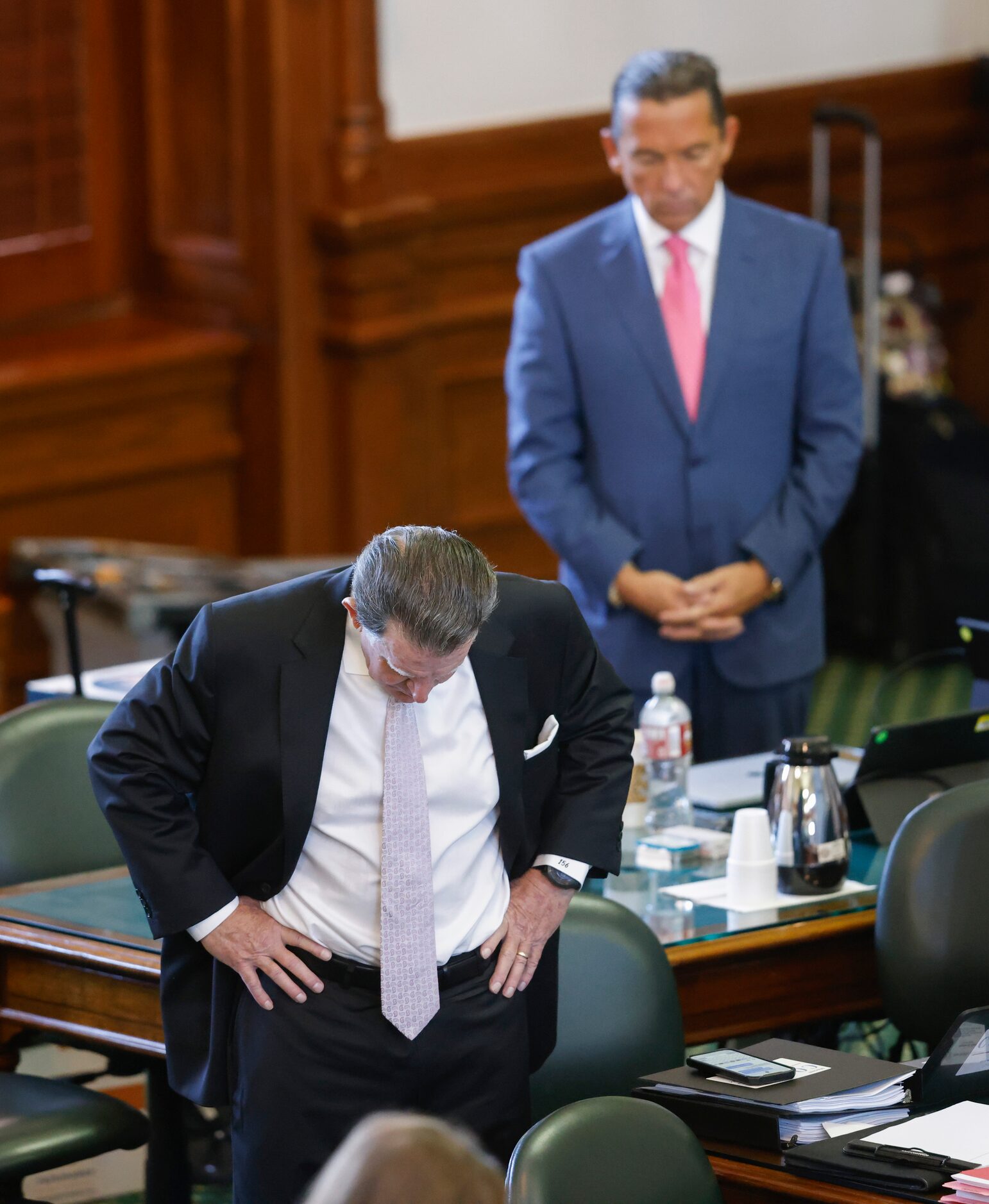 (From left) Defense attorneys Dan Cogdell and Tony Buzbee bow their heads in prayer at the...