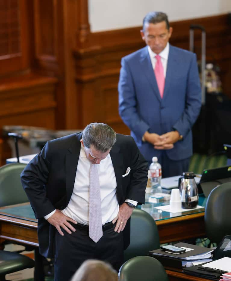 (From left) Defense attorneys Dan Cogdell and Tony Buzbee bow their heads in prayer at the...