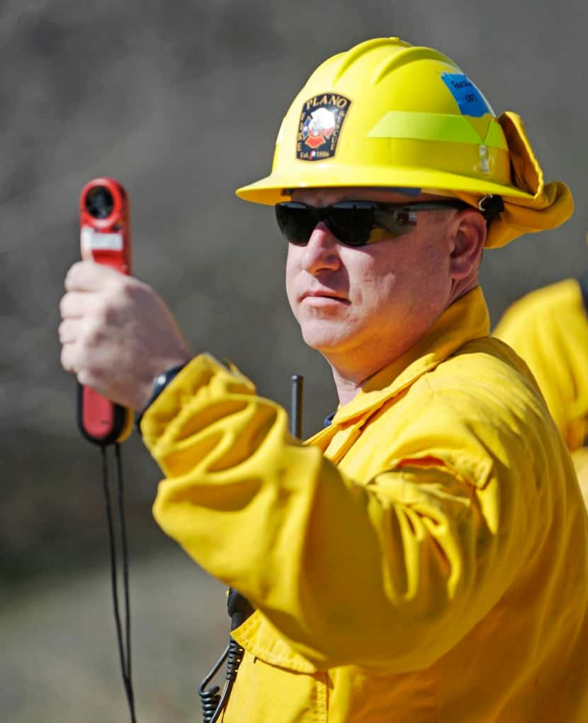 
Plano Fire-Rescue's Matt Frajkor checks the wind before the crew starts a controlled burn...