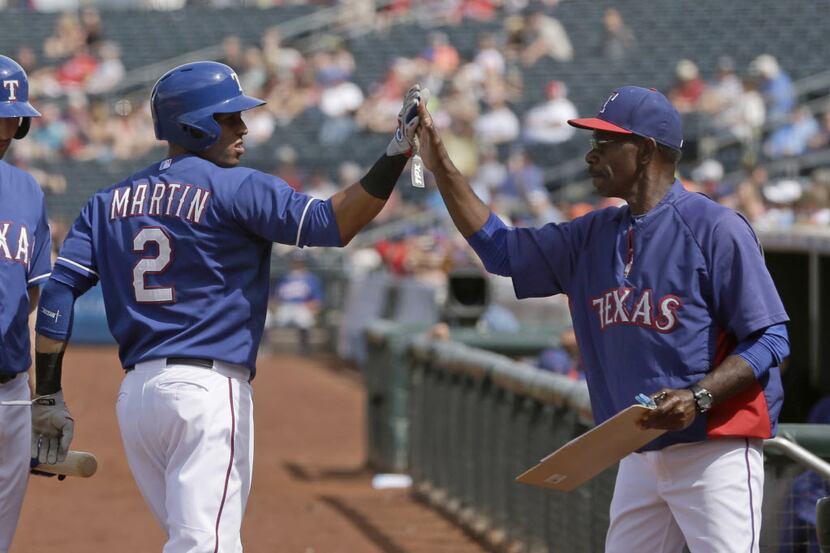 Texas Rangers' Leonys Martin is congratulated by manager Ron Washington after scoring on a...