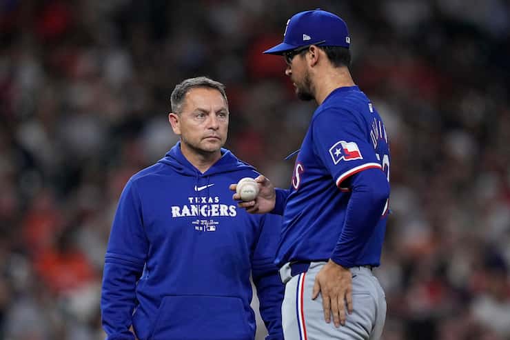 Texas Rangers head athletic trainer Matt Lucero checks on starting pitcher Dane Dunning...