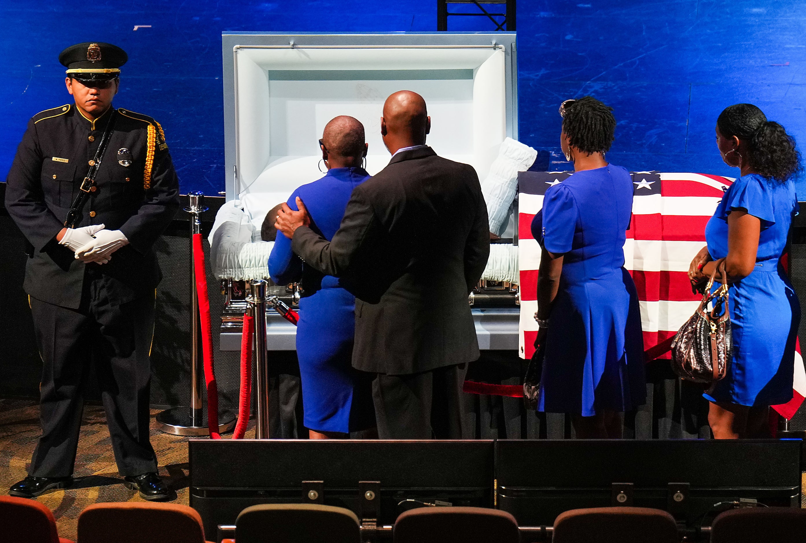 Mourners file past the casket of Dallas police officer Darron Burks before funeral services...