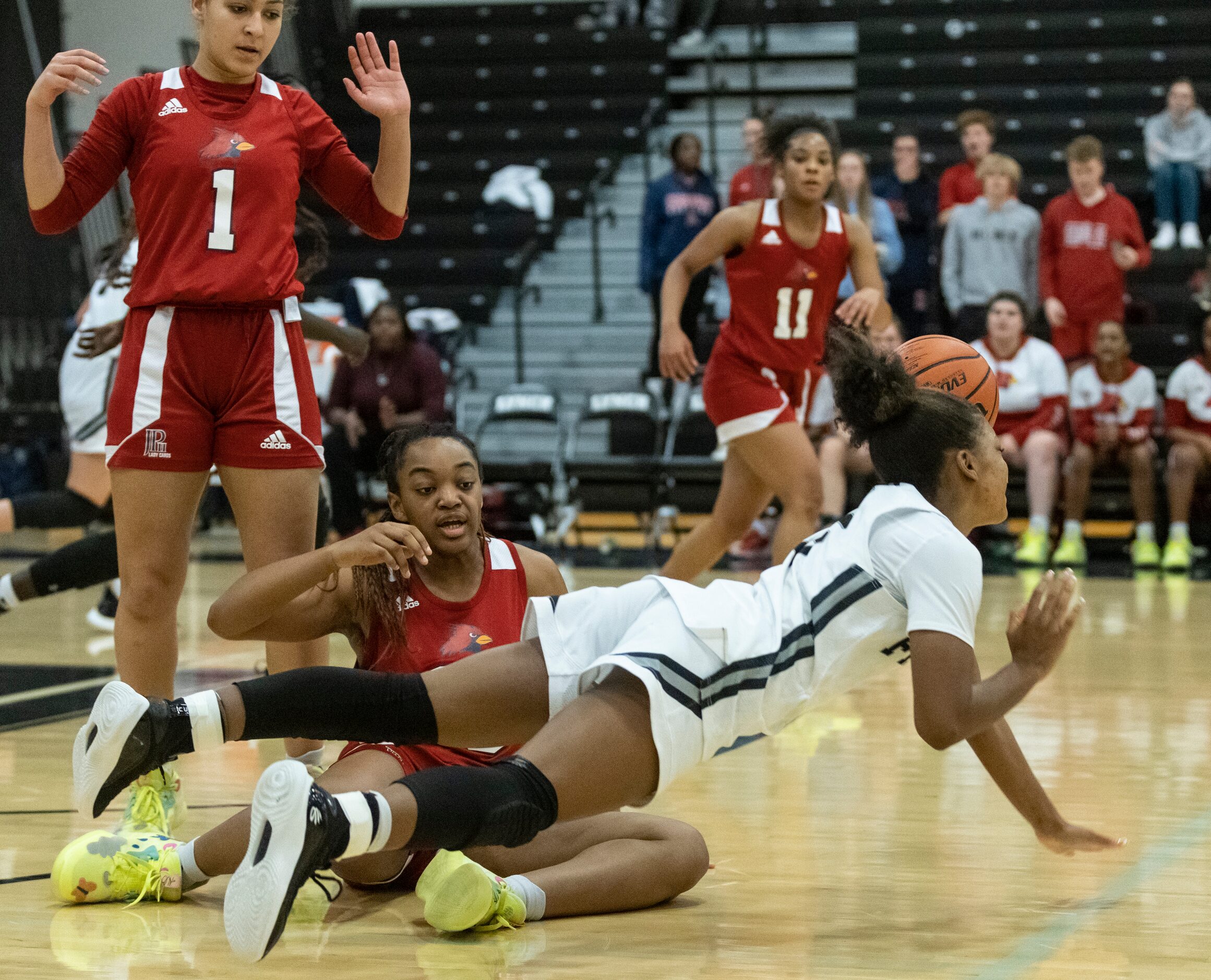 Bishop Lynch High School Maddie Cockrell (5) trips over John Paul II High School Destiny...