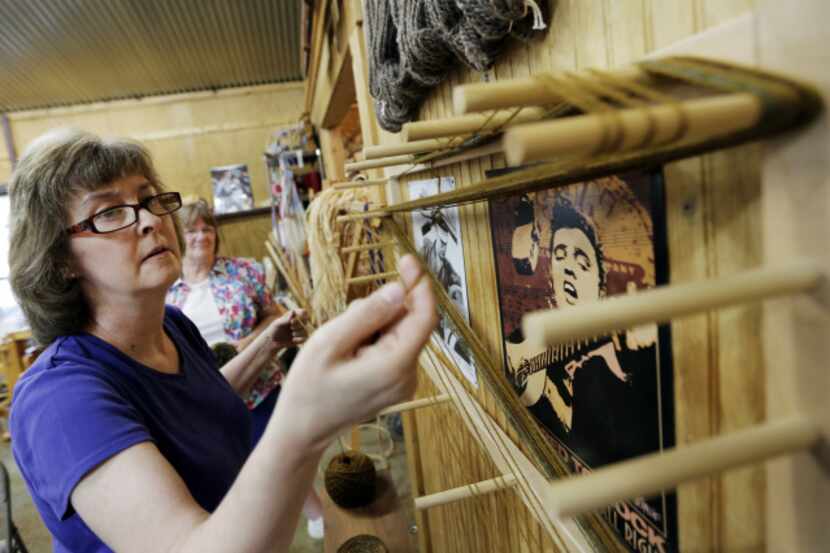 Linda Fleming of Plano stretches yarn between wooden pegs in a process called 'Warping a...