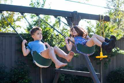 Max Jones, 8, swings with his sister, Quinn, at their home in Dallas.