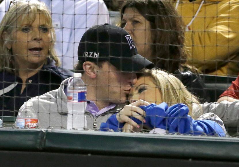 Cleveland Browns quarterback Johnny Manziel, left, kisses a companion during a baseball game...