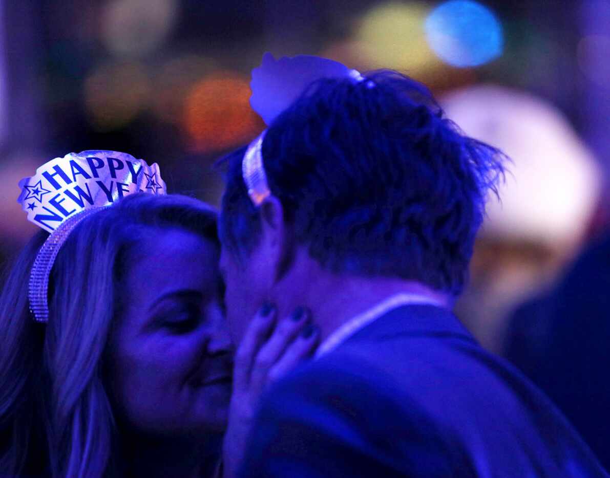 Kim Townsend kisses Chris Queen, both from Plano, during a New Year's Eve party at Saint...