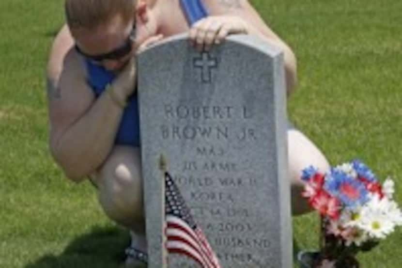  Cheri Anderson weeps at the grave of her father Robert Brown in the Dallas-Fort Worth...