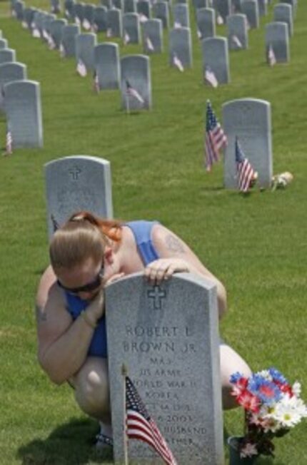  Cheri Anderson weeps at the grave of her father Robert Brown in the Dallas-Fort Worth...