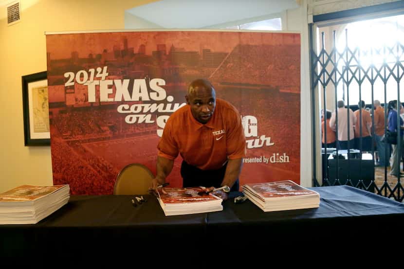 New UT football coach Charlie Strong prepares to sign autographs for University of Texas...