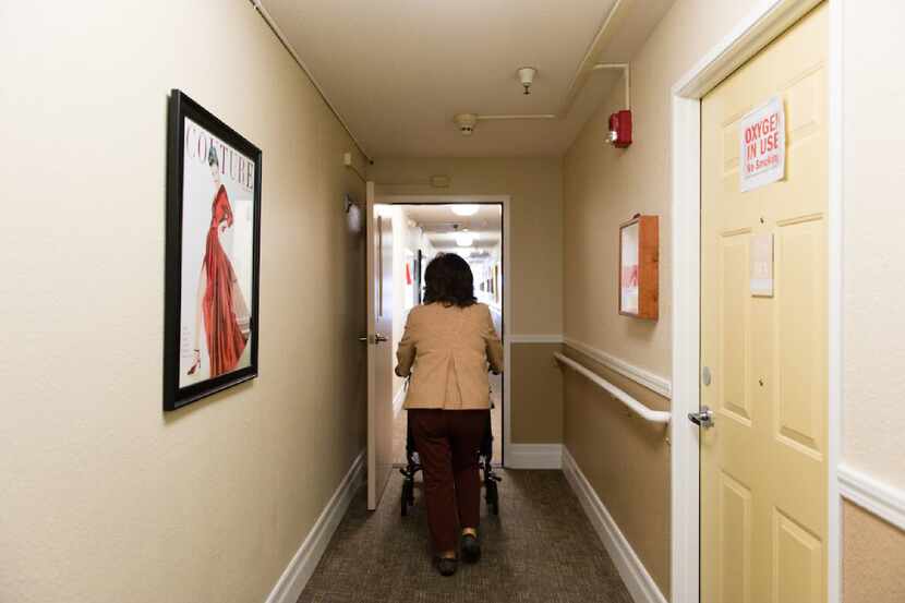Barbara Marquez, 61, wheels her mother down the corridor of the Sagebrook Senior Living home...