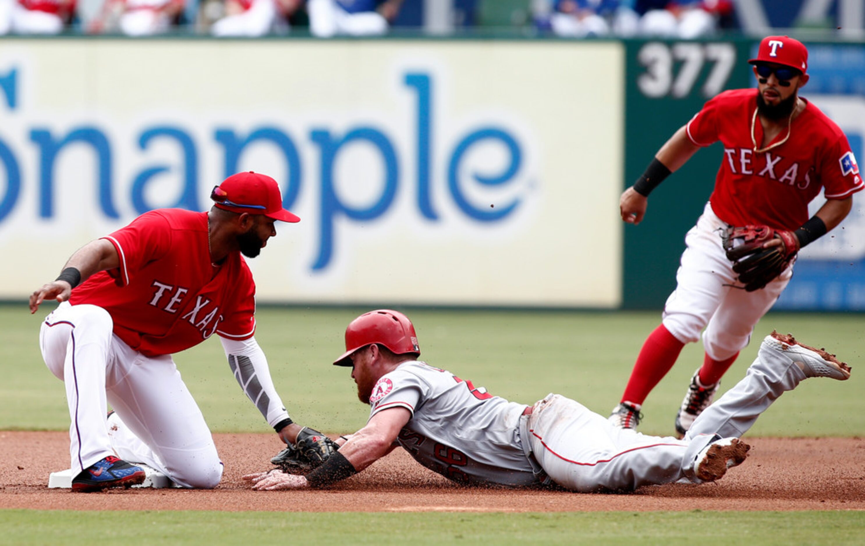 Los Angeles Angels' Kole Calhoun is tagged out by Texas Rangers shortstop Elvis Andrus (1)...