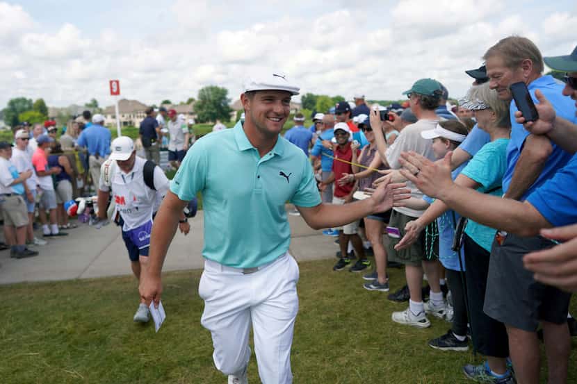 Bryson DeChambeau greets fans as he leaves the ninth hole during the second round of the 3M...