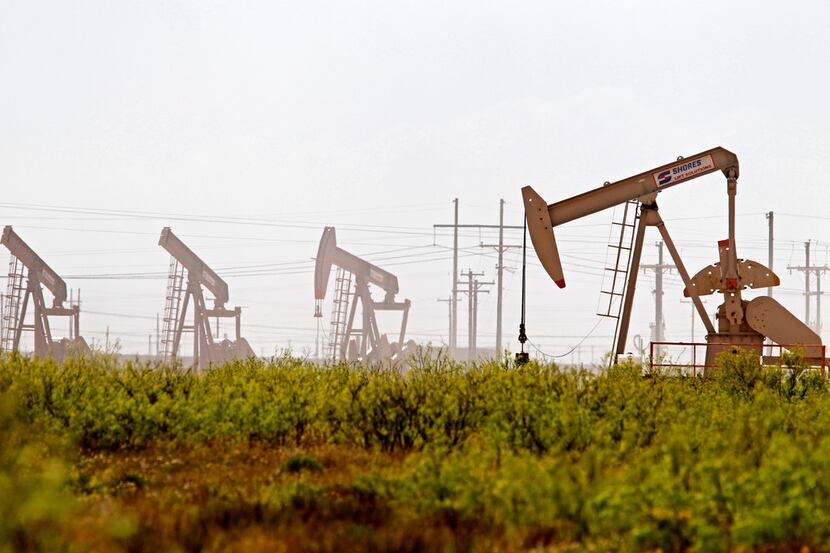 In this April 17, 2019, photo pumpjacks operate near a Diamondback oil and gas operation in...