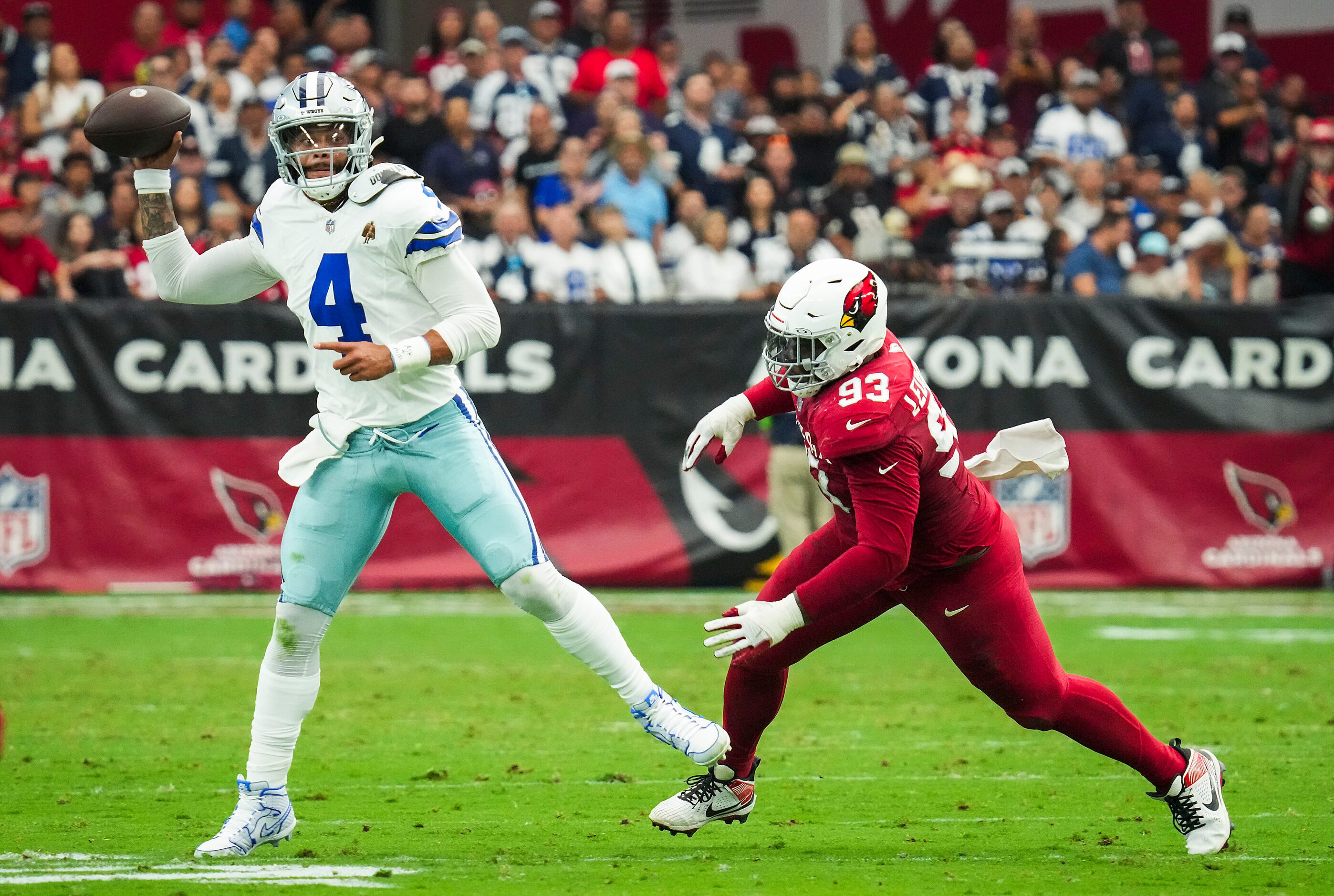 Dallas Cowboys quarterback Dak Prescott (4) throws a pass under pressure from Arizona...