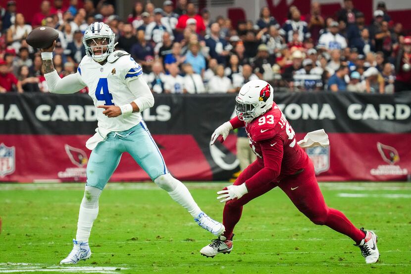 Dallas Cowboys quarterback Dak Prescott (4) throws a pass under pressure from Arizona...