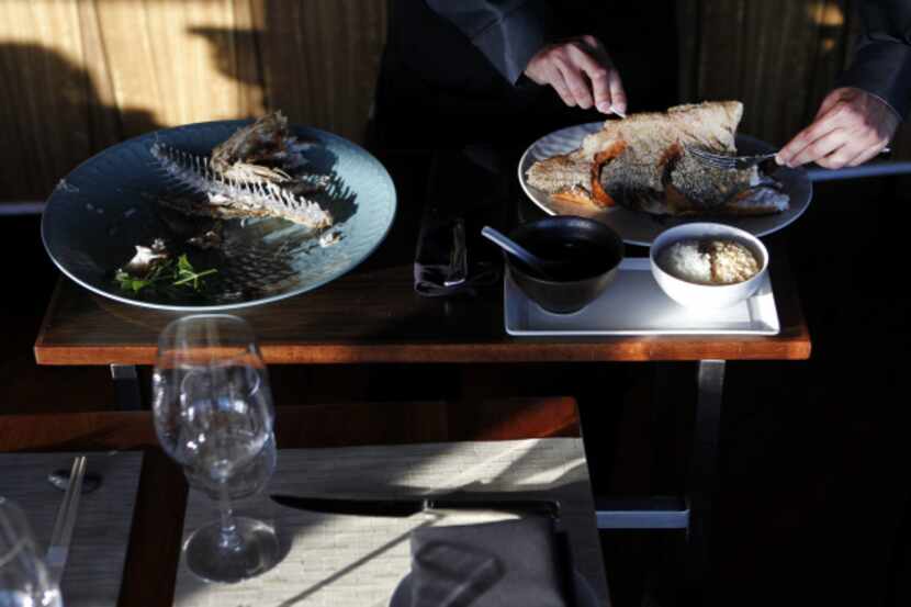 Server Brandon Dsouza fillets the sea bass tableside, then puts the two perfect sides back...