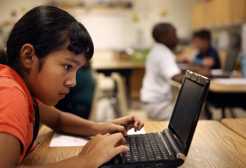 Yesenia Briones, a sixth-grader at Travis Middle School in Irving, uses a netbook during her...
