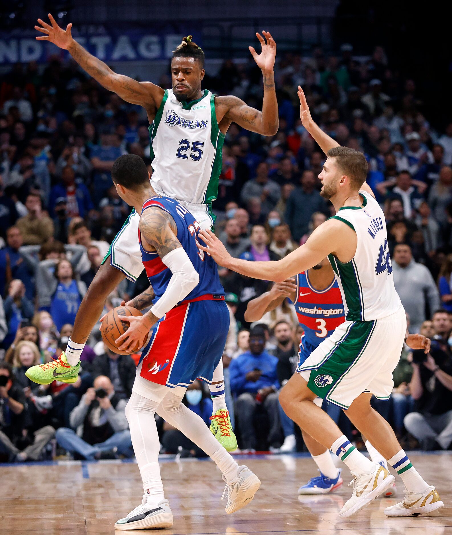 Dallas Mavericks forward Reggie Bullock (25) soars on a double team of Washington Wizards...